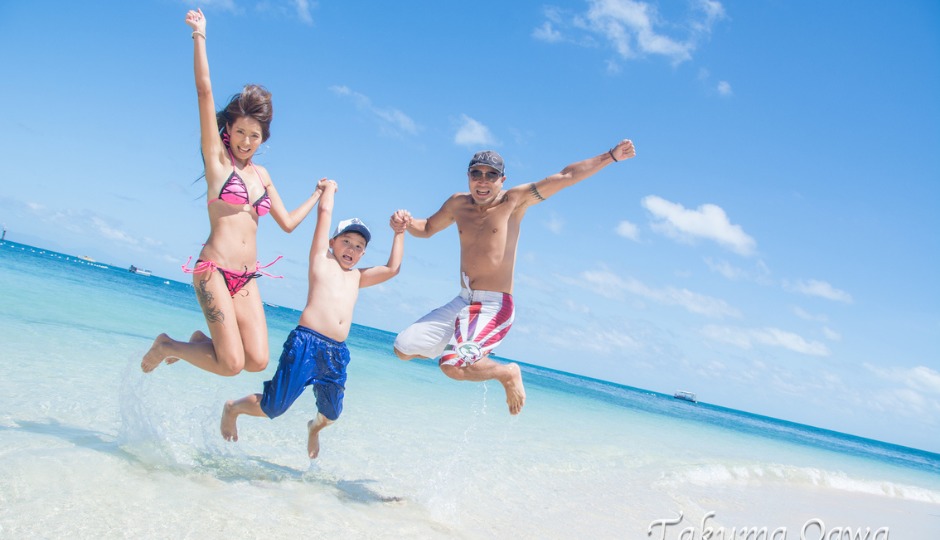 ファミリーがビーチでジャンプ